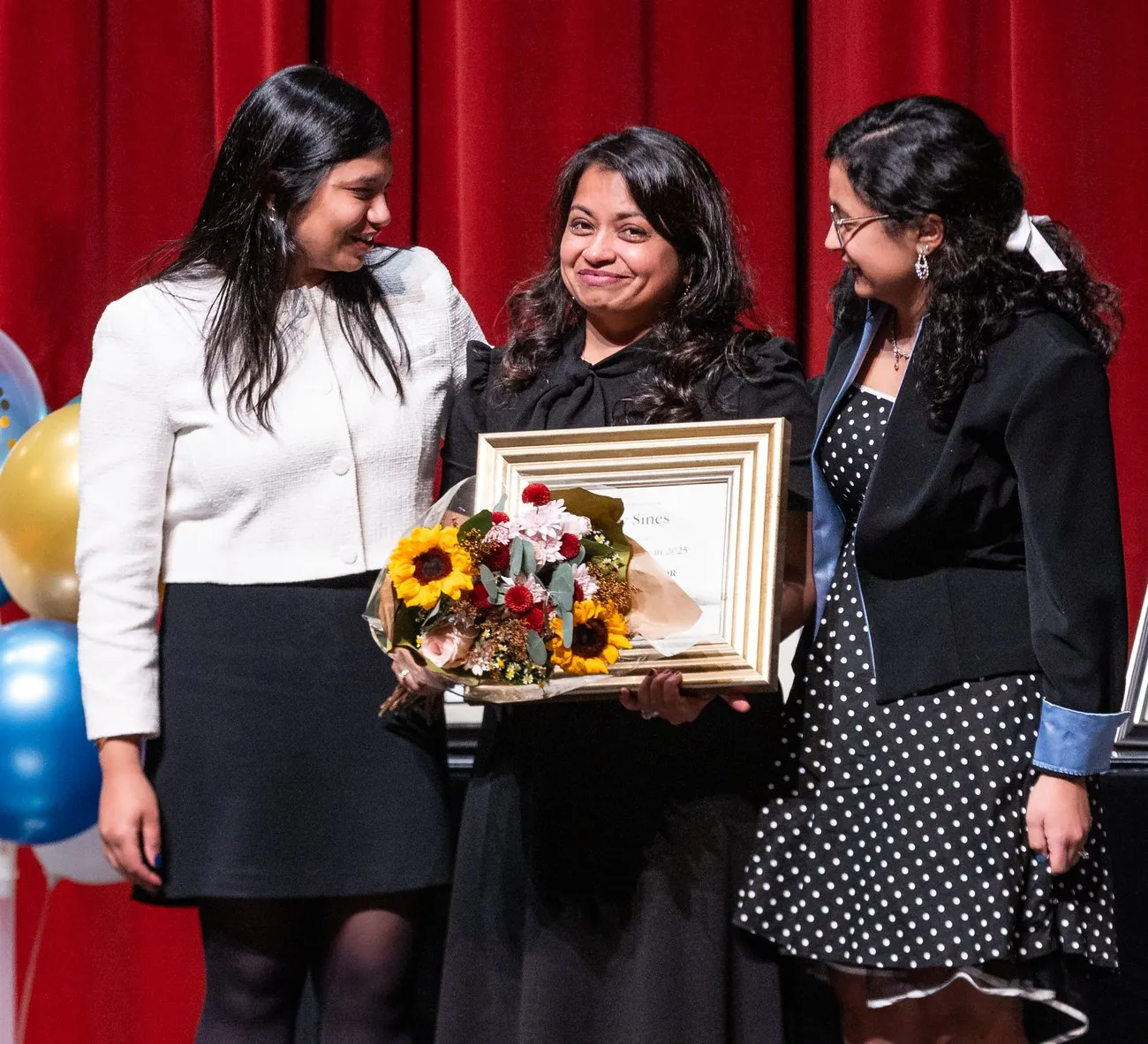 Bincy Sines receiving her Kumon 20-year award with her daughters